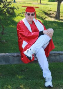 Teenage boy posing for pictures in his graduation cap and gown