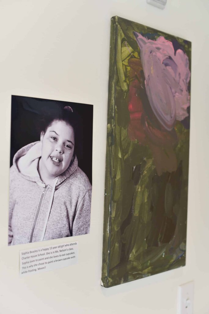 A picture of a painting with a photo of the artist next to it.
