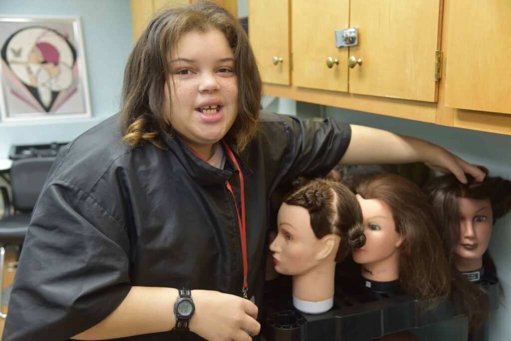 Sophie posing in front of three mannequin head