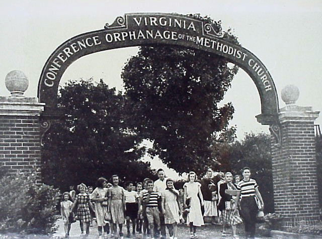Picture of children standing outside under.a sign.