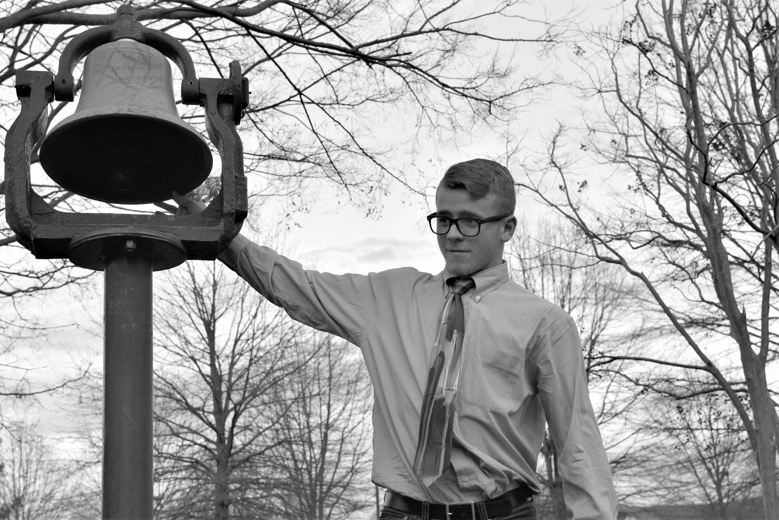 Boy ringing a bell outside.
