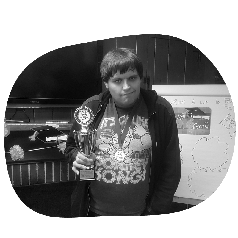 Boy holding a trophy and wearing a medal.