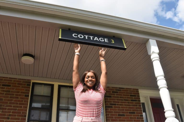 Woman outside standing under a sign