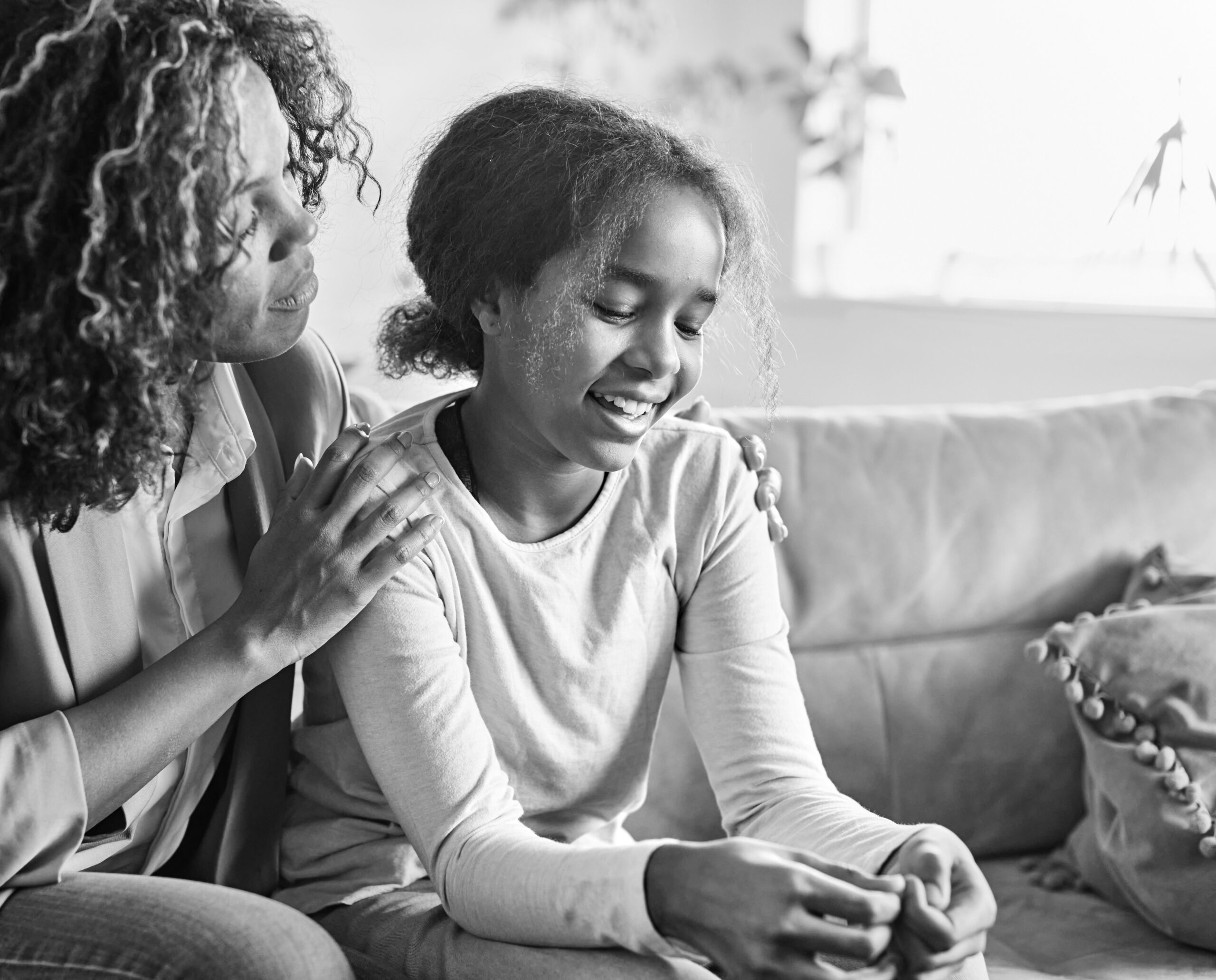 Woman sitting with young girl on. a couch